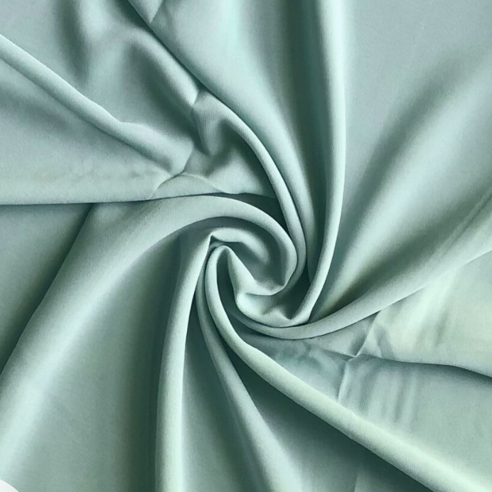 A swatch of ice mint colored chiffon fabric, draped and displayed to show texture and color.